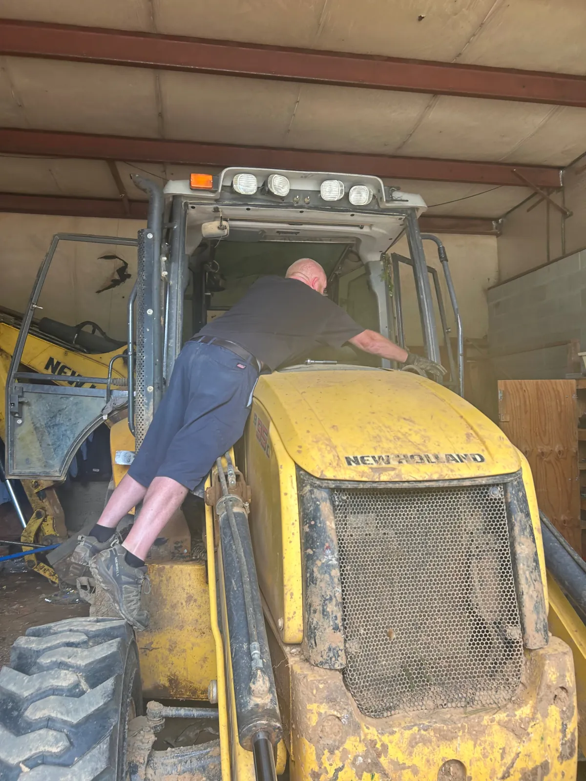 MCA tech prepping a New Holland backhoe cab for heavy equipment glass replacement