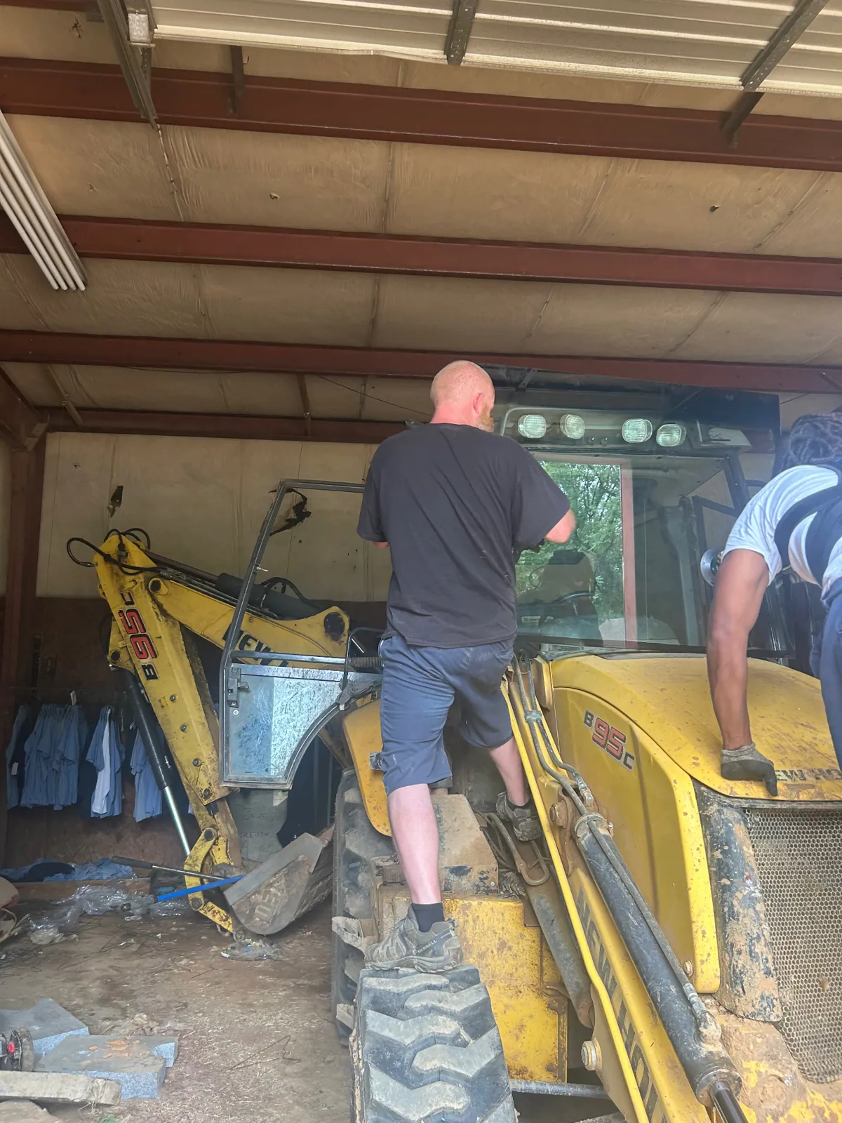 MCA crew installing a new front windshield on a New Holland backhoe in Baltimore