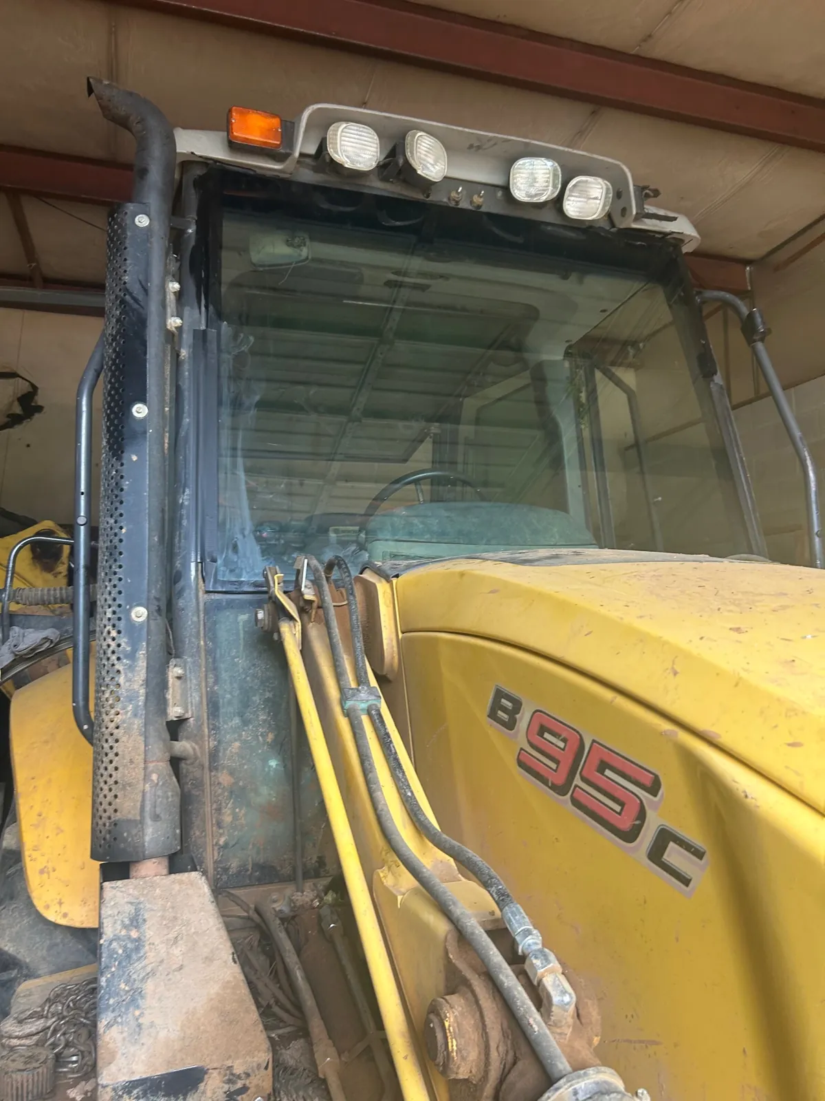 Finished heavy equipment windshield replacement on a New Holland B95c backhoe
