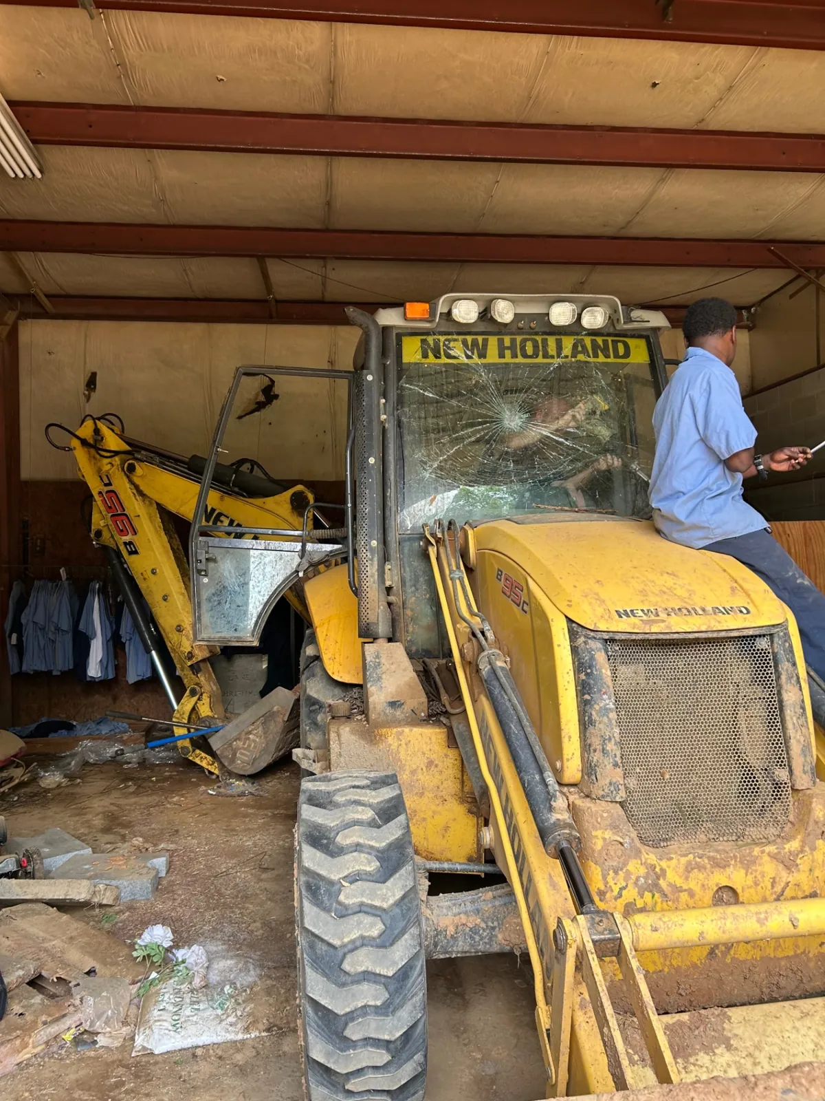 Shattered New Holland B95c backhoe windshield before MCA replacement in Baltimore